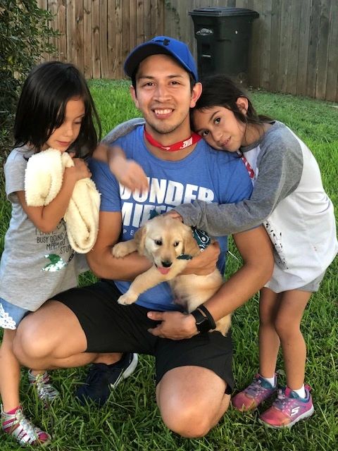 An Alamo Ranch Golden puppy with its new family